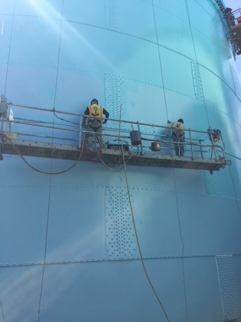 Liberty employees painting on scaffolding